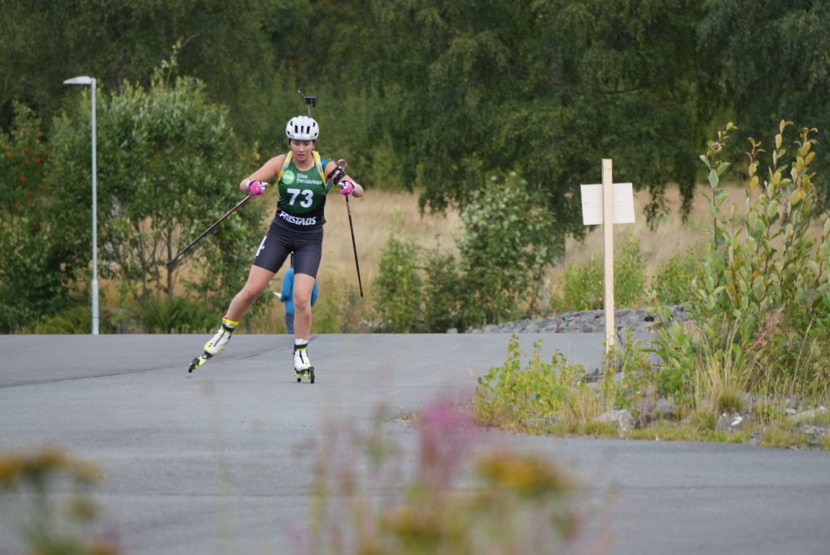 Skidskytt på rullskidor i fart under sommartävling